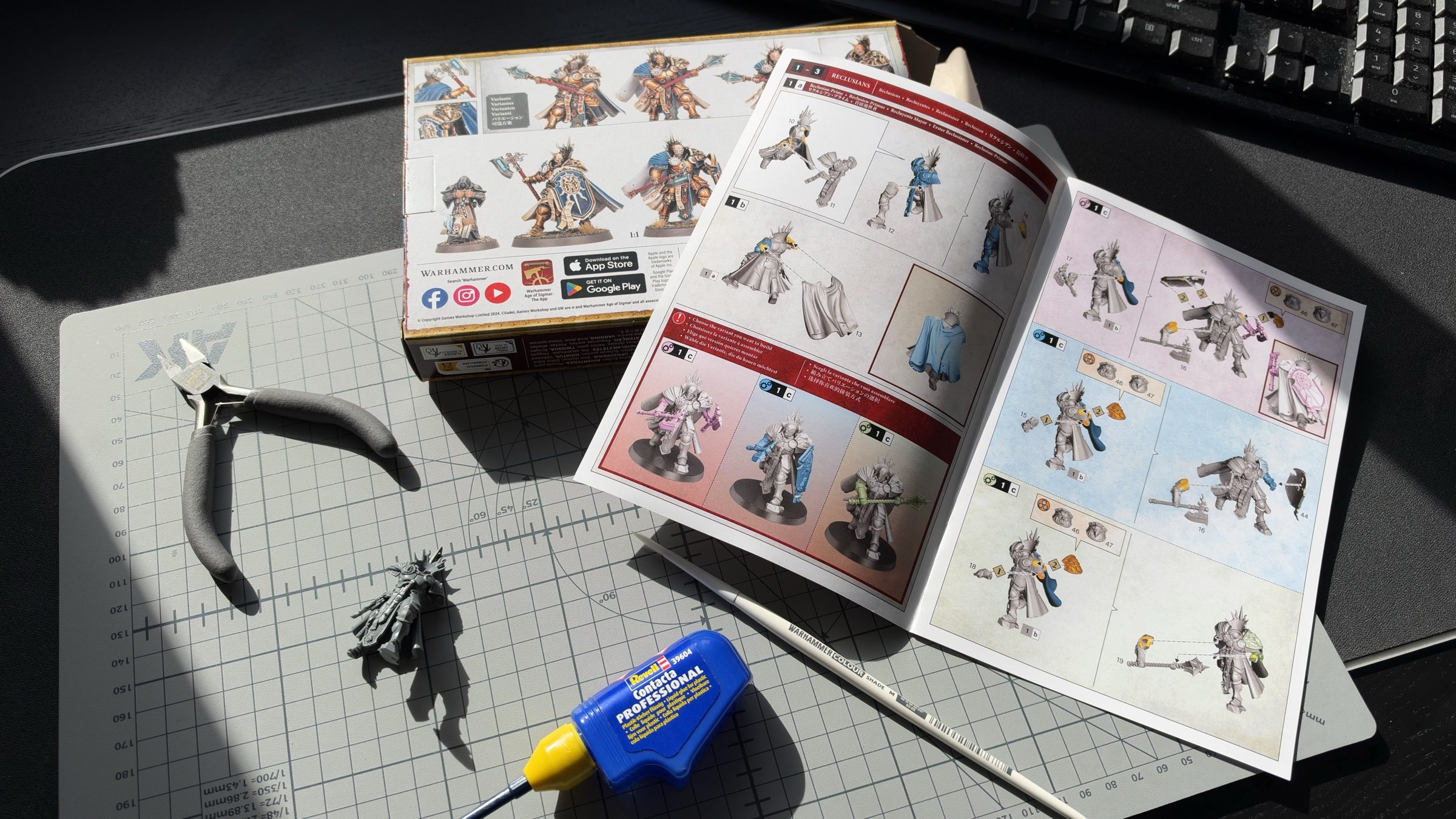 A Stormcast Eternals Spearhead box and its open assembly instructions on a cutting mat, with clippers, plastic glue, a brush and a half-built model